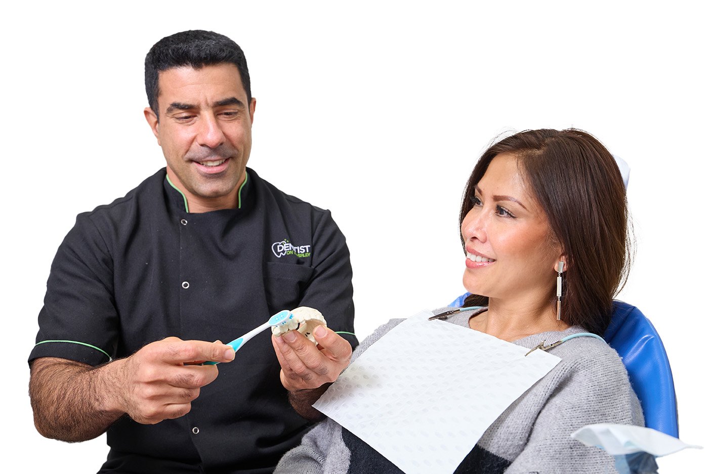 A dentist explaining treatment options to a patient using a model of the teeth